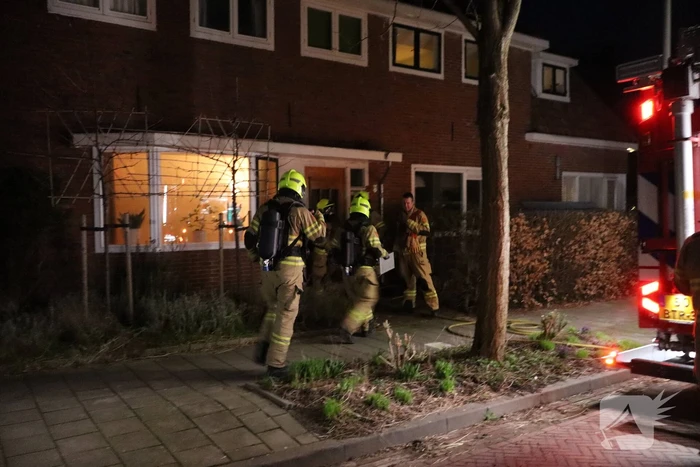 Rook in woning door smeulend hout op kachel