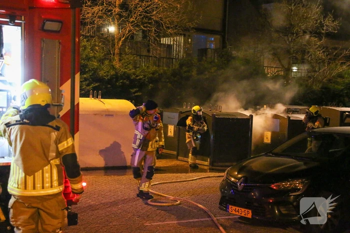 Brandweer blust brandende papiercontainer