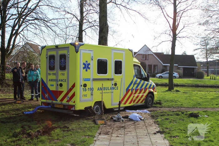 Vastgereden ambulance losgetrokken door graafmachine