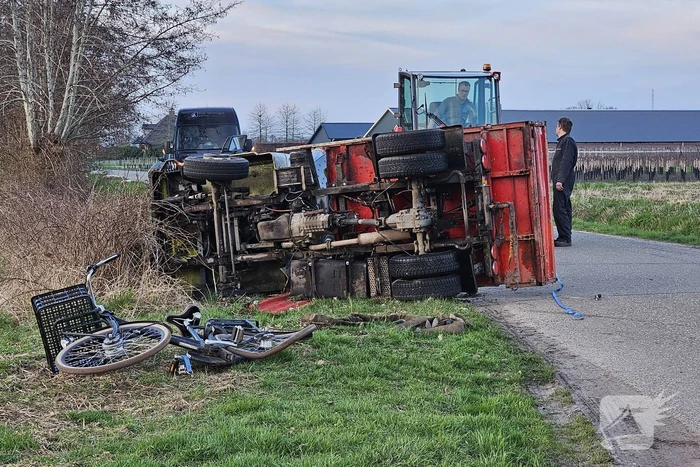 Gekantelde landbouwvoertuig plet fiets