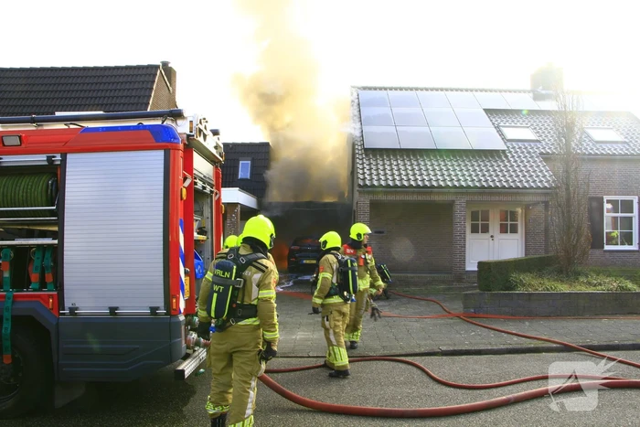 Personenauto vat vlam onder carport