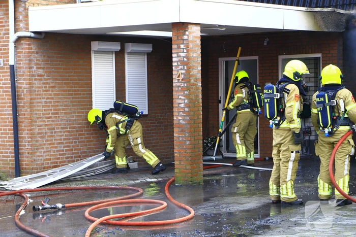 Personenauto vat vlam onder carport