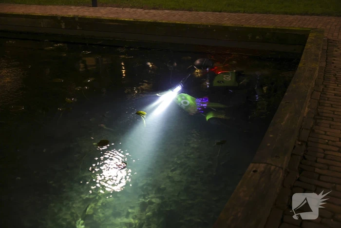Personen dumpen scooter in vijver met karpers
