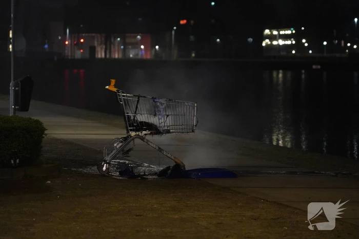 Winkelwagen met afval bij daklozenopvang in brand gestoken