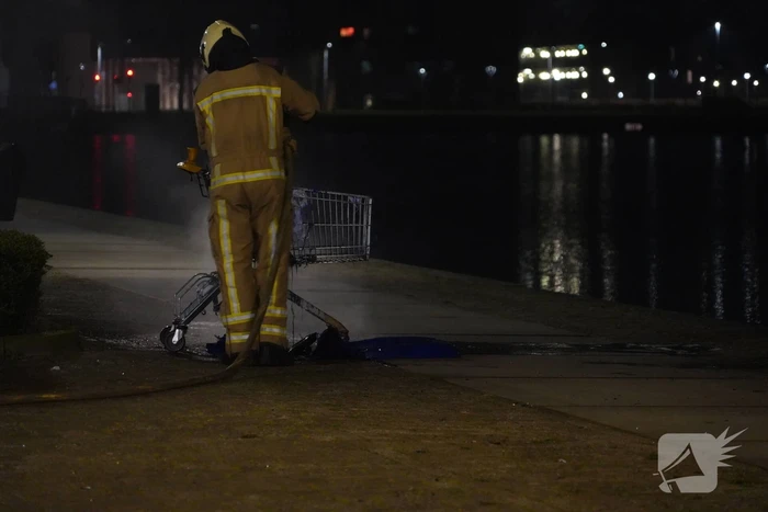 Winkelwagen met afval bij daklozenopvang in brand gestoken
