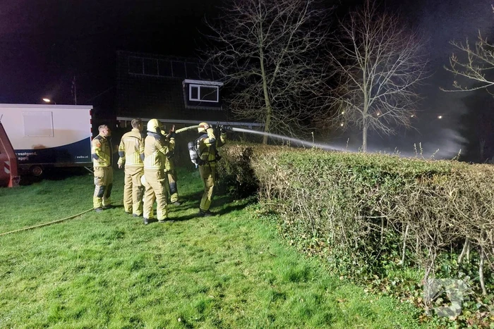 Brandweer blust brandende prullenbak