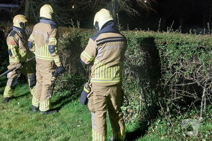 Brandweer blust brandende prullenbak