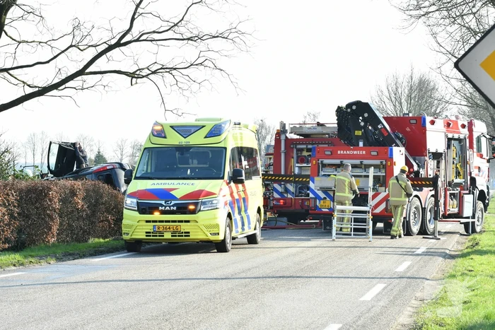 Auto raakt van de weg en belandt op zijkant in voortuin