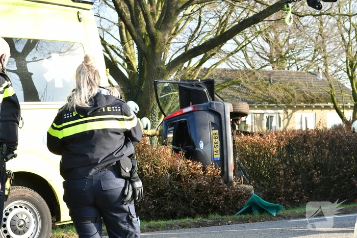 Auto raakt van de weg en belandt op zijkant in voortuin