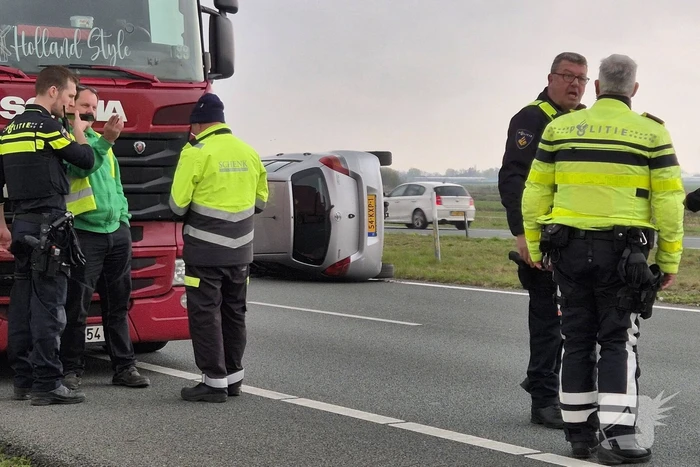 Auto op zijn kant na ongeval met vrachtwagen
