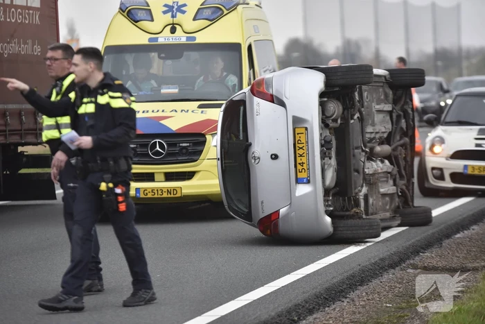 Auto op zijn kant na ongeval met vrachtwagen