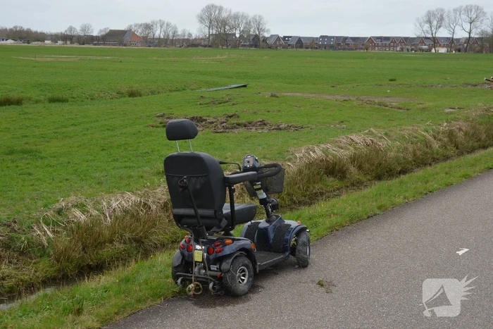 Persoon in scootmobiel raakt te water
