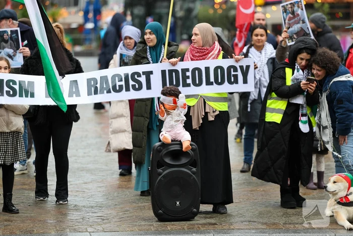 Demonstrant klimt op gebouw naast gemeentehuis