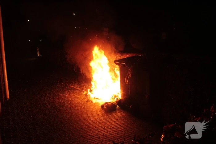 Brandweer blust kliko's die dicht bij pand staan