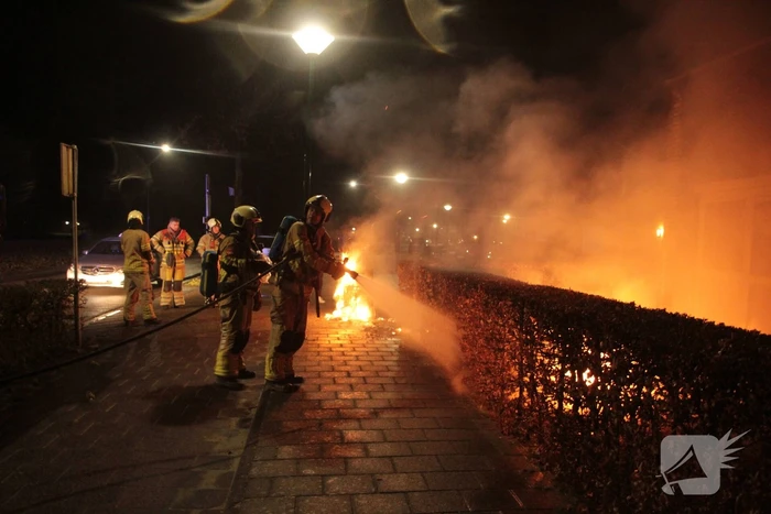 Brandweer blust kliko's die dicht bij pand staan