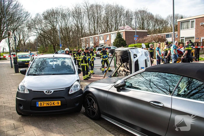 Auto kantelt na rijden tegen stilstaande auto's