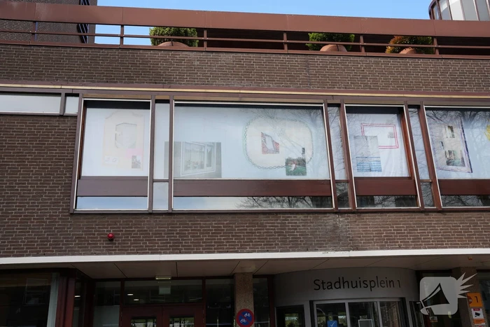 Tekeningen, foto's en bouwtekeningen als raamkunstwerk bij stadshuis