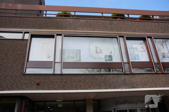 Tekeningen, foto's en bouwtekeningen als raamkunstwerk bij stadshuis