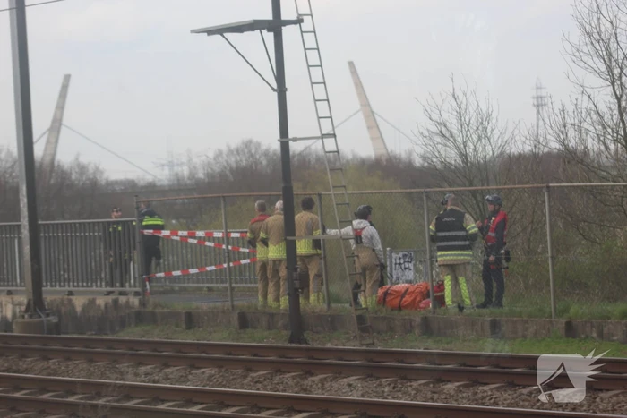 Persoon op bogen van brug, vele hulpdiensten aanwezig