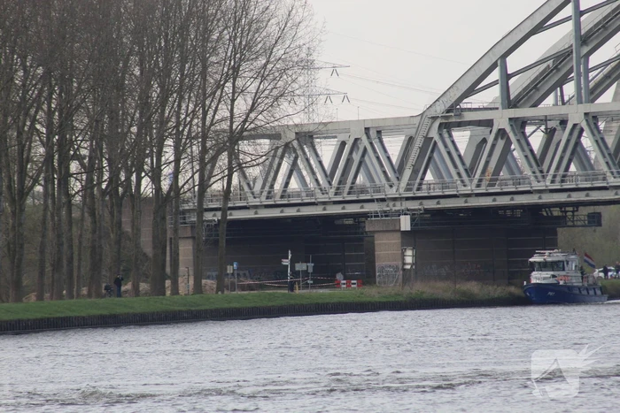 Persoon op bogen van brug, vele hulpdiensten aanwezig