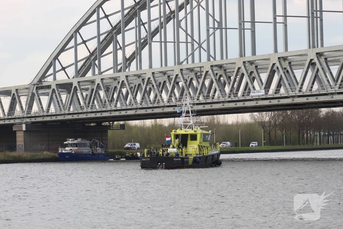 Persoon op bogen van brug, vele hulpdiensten aanwezig