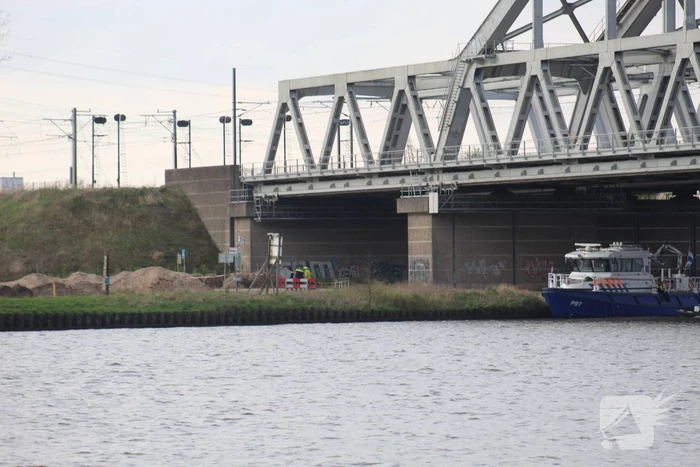 Persoon op bogen van brug, vele hulpdiensten aanwezig