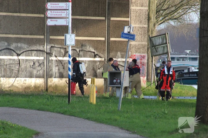 Persoon op bogen van brug, vele hulpdiensten aanwezig
