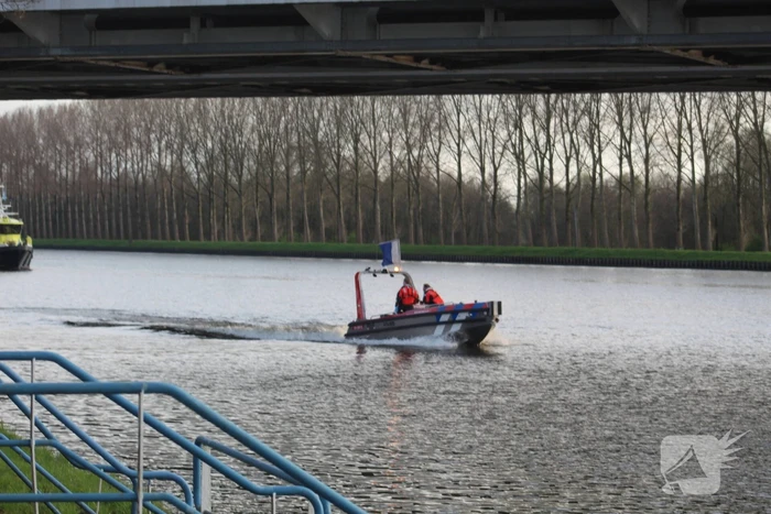 Persoon op bogen van brug, vele hulpdiensten aanwezig