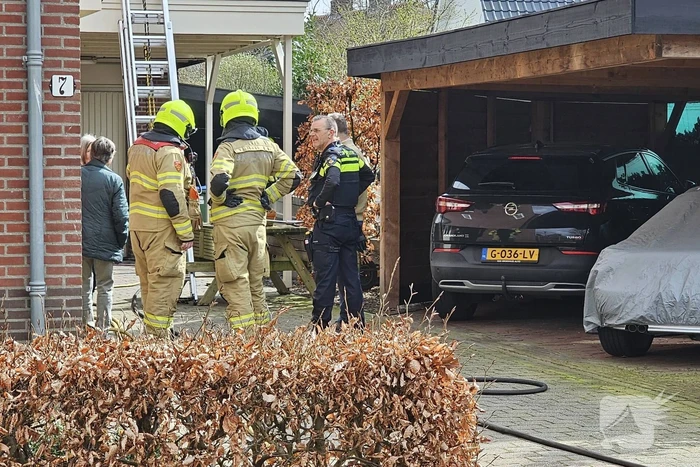 Bewoners starten blussing van brand onder carport