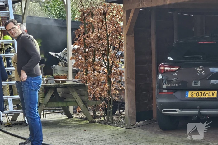 Bewoners starten blussing van brand onder carport