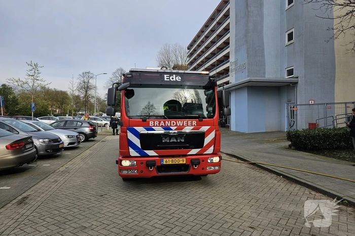 Motor in brand naast flatgebouw