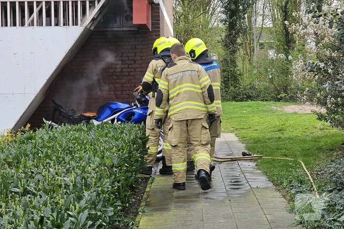 Motor in brand naast flatgebouw