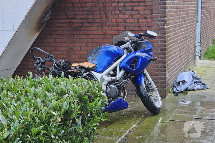 Motor in brand naast flatgebouw