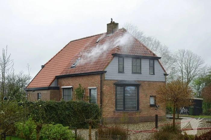 Brandweer blust brand in dak van woonboerderij