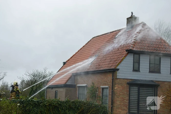 Brandweer blust brand in dak van woonboerderij