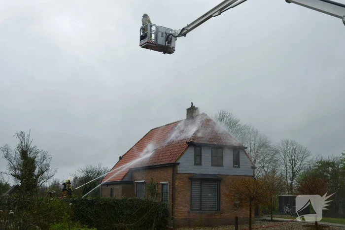 Brandweer blust brand in dak van woonboerderij