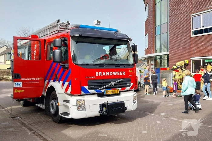 Kind bekneld tussen hek en betonnen container