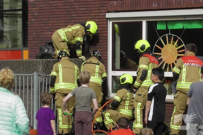 Kind bekneld tussen hek en betonnen container