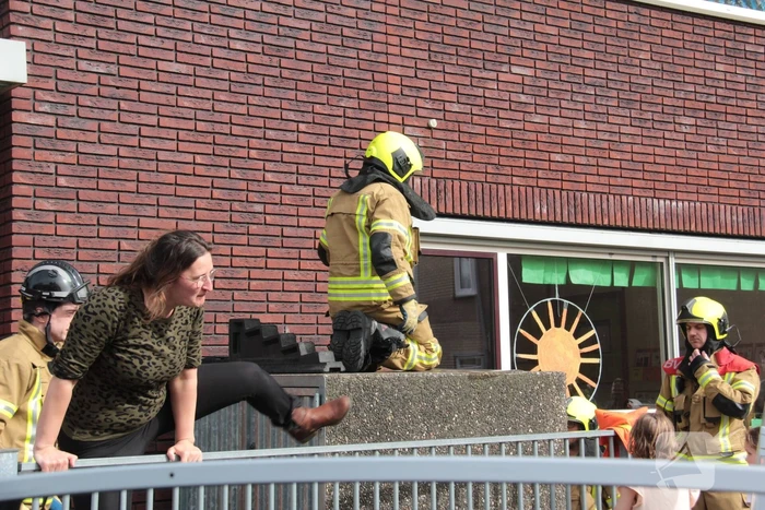 Kind bekneld tussen hek en betonnen container
