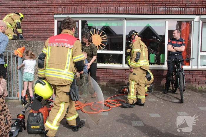 Kind bekneld tussen hek en betonnen container
