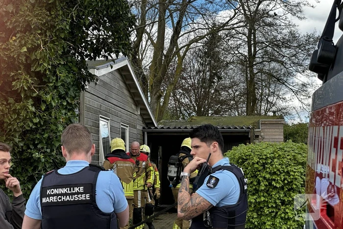 Brandweer blust brand achter woning