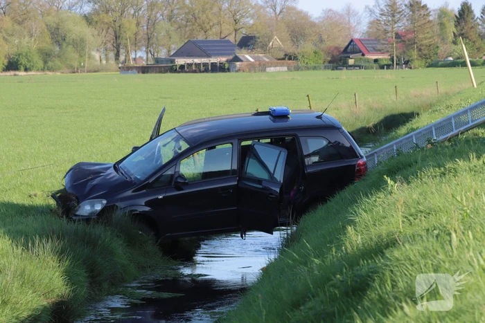 Automobilist raakt van de weg en blijft boven sloot hangen