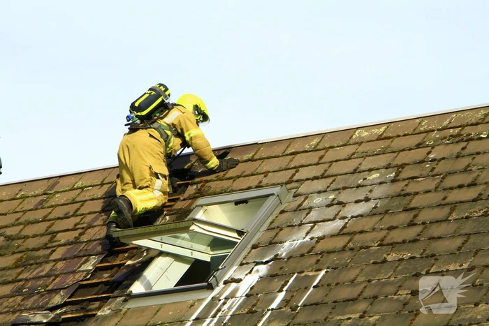 Brandweer breekt dak open om brand te bestrijden