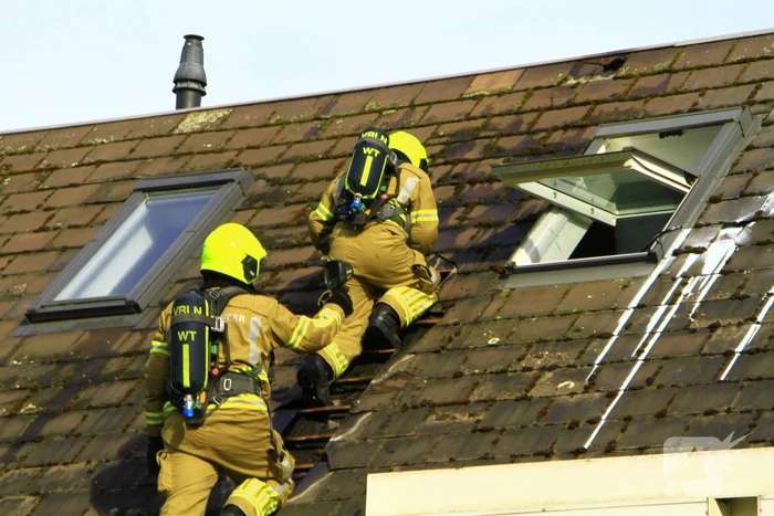 Brandweer breekt dak open om brand te bestrijden