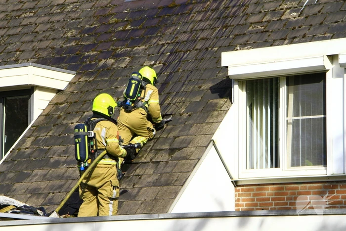 Brandweer breekt dak open om brand te bestrijden