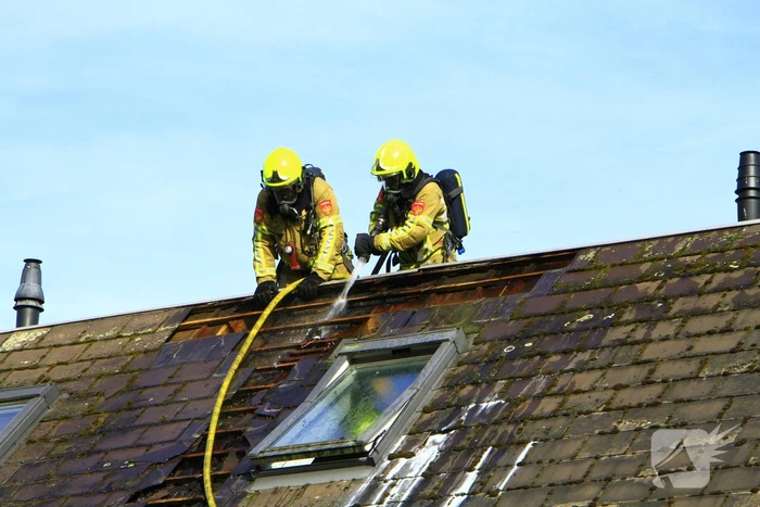Brandweer breekt dak open om brand te bestrijden