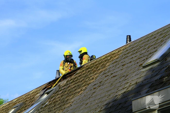 Brandweer breekt dak open om brand te bestrijden