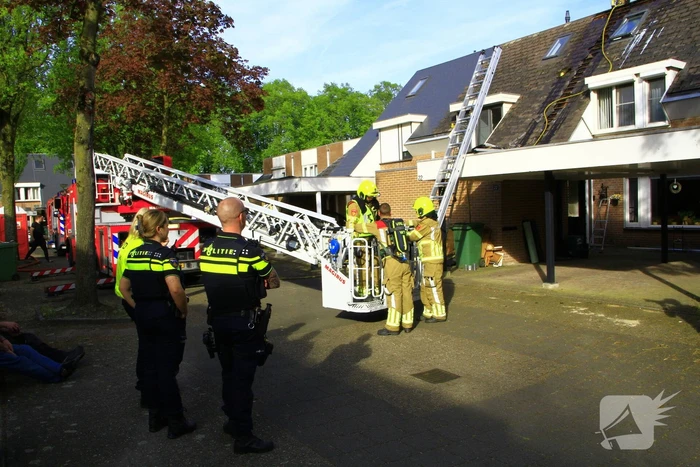 Brandweer breekt dak open om brand te bestrijden