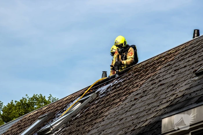 Brandweer breekt dak open om brand te bestrijden