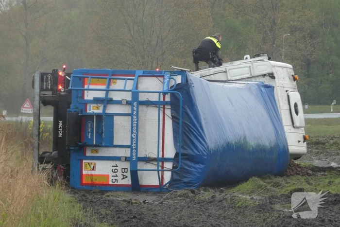 Vrachtwagen raakt van de weg en kantelt
